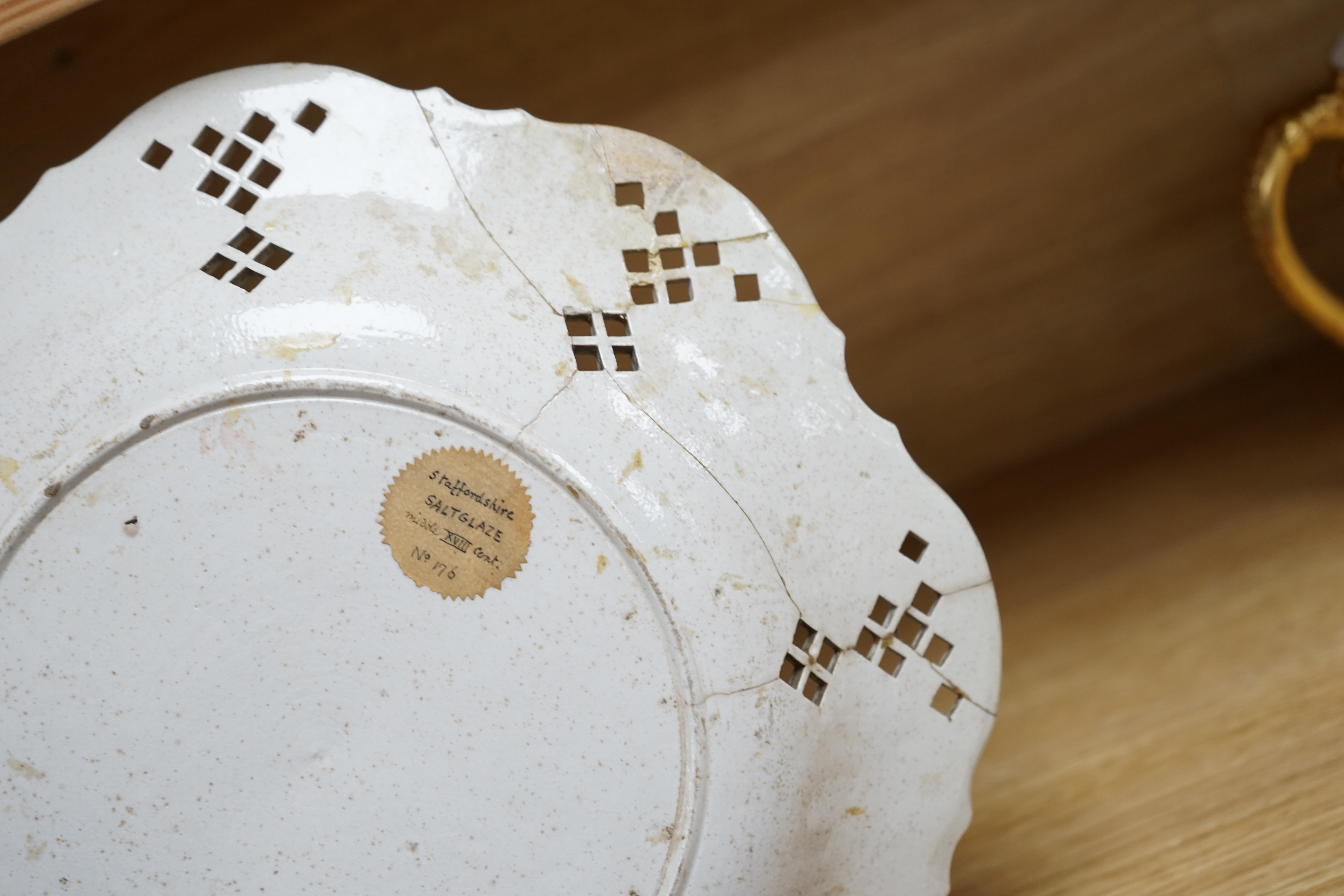 An 18th century white salt-glaze dish, diameter 31cm. (a.f.). Condition - poor, significant cracks and repair